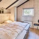 Schlafzimmer mit Holzwand, Bett, Stuhl und Fenster