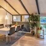 Essbereich mit Tisch, Stühlen und Pflanzen. Wohnbereich mit Sessel und Fenster.