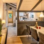 Essbereich mit Tisch und Stühlen, Küche im Hintergrund, Holzwände und Decke