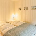 Schlafzimmer mit Bett, Wandleuchten und Stuhl an der Wand.