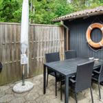 Hinterhof mit Grill, Tisch und Stühlen. An der Wand hängt ein Rettungsring.