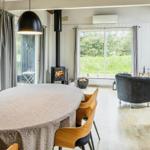 Essbereich mit Tisch und Stühlen, Kamin und Blick auf die Terrasse.