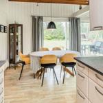 Küche mit Esstisch und Sicht auf Garten. Holzfußboden und moderne Geräte.