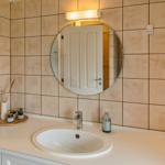 Bad mit Waschbecken, Spiegel und Fliesenwand