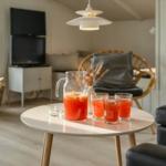 Runde Tisch mit Getränken, Sessel und Fernseher im Wohnzimmer.