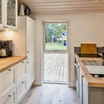 Küche mit Holz Arbeitsplatten, Fenster zur Terrasse und moderner Spüle.