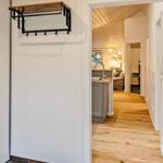 Hallenflur mit Holzboden und Blick in Küche und Wohnzimmer