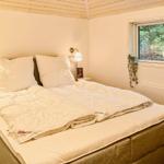 Schlafzimmer mit Doppelbett, Fenster und Wandlampen.