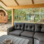 Terrasse mit Sitzgruppe und Blick auf Wald und Holzhaus