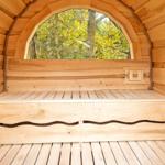 Holzsauna mit Sitzbank und Bogenfenster zum Wald