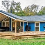 Blauer Holzhaus mit Terrasse und Garten. Außendeko und Sitzgelegenheiten.