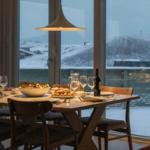 Esstisch mit Speisen vor großem Fenster mit winterlichem Blick