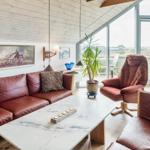 Wohnzimmer mit Ledersofa, Couchtisch und Blick auf Terrasse