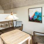 Wohnzimmer mit Ledersofa, Holztisch und Wandbild.