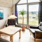Wohnzimmer mit Sitzgelegenheiten, Tisch und Blick auf Außenbereich.