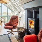 Wohn- und Essbereich mit Kamin, Sessel und großem Fenster