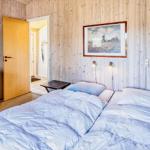 Schlafzimmer mit Holzwand, Bett, Schrank und Bild an der Wand.