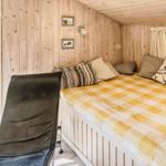 Schlafzimmer mit Holzwand, Bett mit gelbem Decken und Fensterblick.