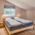 Schlafzimmer mit Holzwand, Bett und Fenster