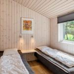 Zwei Betten in einem Holzraum mit Fenster und Wandbild.