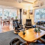 Wohnzimmer mit Ledersofa, Holztisch und Blick in Essbereich