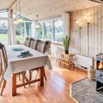 Esszimmer mit Holzwand, Kamin und großem Fensterblick auf Garten