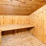 Holzsauna mit Sitzbank und Heizung.