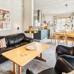 Wohnzimmer mit Sofa, Sessel und Esstisch. Küche und Schlafzimmer sind sichtbar.