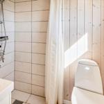 Badezimmer mit Dusche, Toilette und Waschbecken.