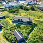 Aerial view of modern holiday homes among greenery and pathways.