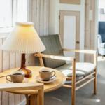 Ruhiger Raum mit Holzmöbeln, Lampe und zwei Tassen auf Tisch