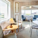 Wohnzimmer mit Essbereich, Holzwand und Fensterblick