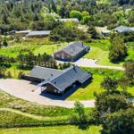 Aerial view of several vacation cabins surrounded by green grass and trees.