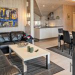 Wohnzimmer mit Ledersofa, Esstisch und Küchenbereich