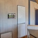 Küche mit Kühlschrank und eingebauter Mikrowelle an Holzwand