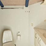 Badezimmer mit Toilette, Waschbecken und Spiegel