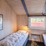 Zwei Betten, Holzwände, Fenster und Bild an der Wand.