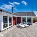 Wohnhaus mit Terrasse, Liegen und Blick auf Dünen.