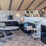 Wohnbereich mit Sofa, Sessel und Küchenzeile.
