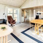 Wohn- und Essbereich mit Holzmöbeln, Sofa und Kaminofen.