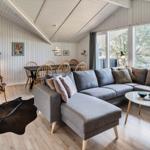Wohnzimmer mit großem Sofa, Esstisch und Blick auf den Garten