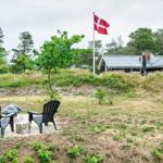 Haus mit Grillplatz und dänischer Flagge im Grünen