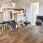 Essbereich mit Holztisch und Stühlen, Sofa, Kamin und Wandbild.