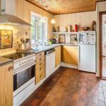 Küche mit Holzschrank, Steinplatten und Blick in Esszimmer