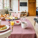Frühstückstablett mit Brot, Obst und Getränken vor Fenster
