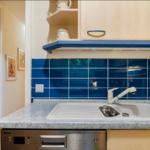 Küche mit blauer Fliesenspiegelwand, Spüle und Küchenspüle