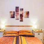 Schlafzimmer mit Doppelbett, Nachttischen und Wandbildern.