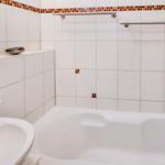 Badezimmer mit Badewanne, Waschbecken und Spiegel.