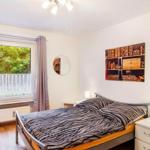 Schlafzimmer mit Bett, Fenster und Wandbild.