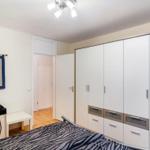 Schlafzimmer mit Bett, Kleiderschrank und Wandbehang.